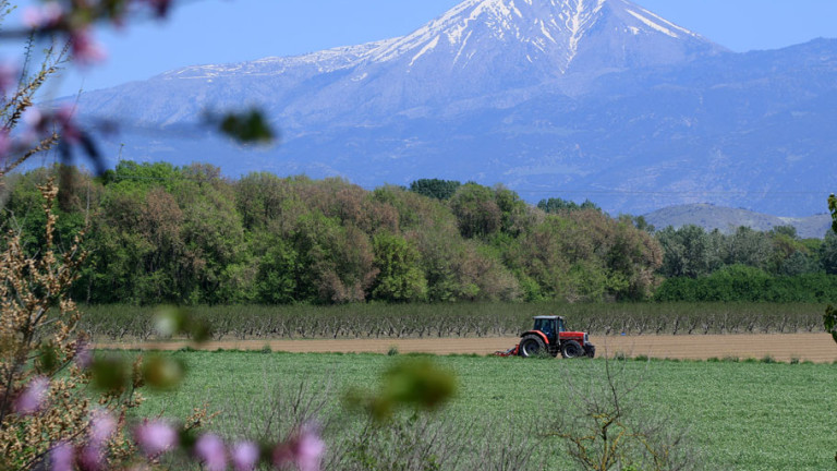 Αγρότης με τρακτέρ σε χωράφι