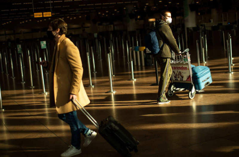κόσμος με βαλίτσες και ψηφιακό πιστοποιητικό σε αεροδρόμιο