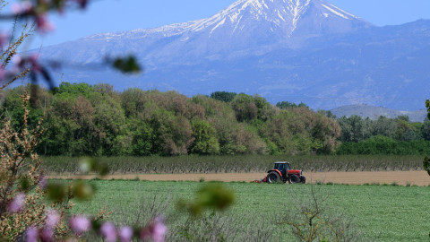 Αγρότης με τρακτέρ σε χωράφι