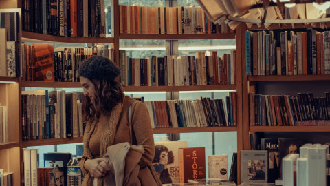 Κοπέλα κοιτάζει βιβλία σε βιβλιοπωλείο
