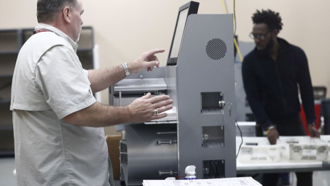 Υπάλληλοι τοποθετούν ψηφοδέλτια στις συσκευές ανάγνωσης στο πλαίσιο της επανακαταμέτρησης ψήφων στη Φλόριντα 