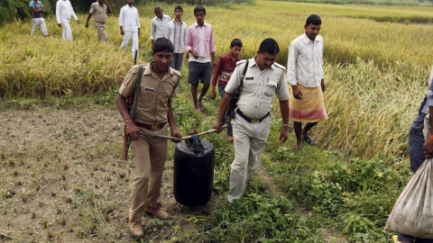 Ινδοί αστυνομικοί μεταφέρουν ποσότητα νοθευμένου που κατασχέθηκε στη διάρκεια εφόδου