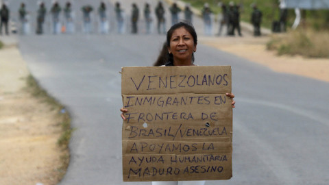 Διαδηλωτής με το σύνθημα «Μετανάστες από τη Βενεζουέλα στα σύνορα με τη Βραζιλία, υποστηρίζουμε την ανθρωπιστική βοήθεια, Μαδούρο δολοφόνε» / Φωτό: AP Images