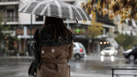 Καιρός κακοκαιρία / γυναίκα με ομπρέλα στη βροχή