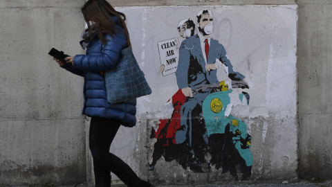 Μια Ιταλίδα περπατά μπροστά από γκράφιτι