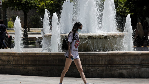 κοπέλα με μάσκα κοντά σε συντριβάνι στην Αθήνα