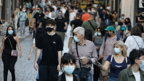 Πολίτες με μάσκες περπατούν στην ερμού