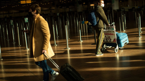 κόσμος με βαλίτσες και ψηφιακό πιστοποιητικό σε αεροδρόμιο