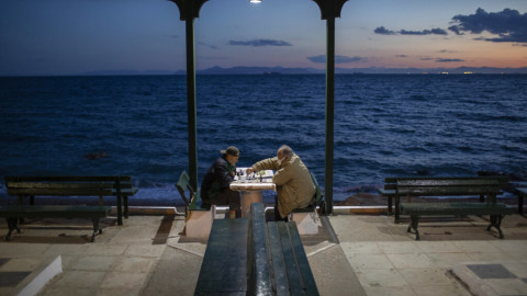 Δυο άνδρες παίζουν σκάκι μπροστά στη θάλασσα