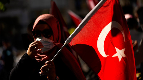 γυναίκα με μπούργκα, μάσκα και τουρκική σημαία 
