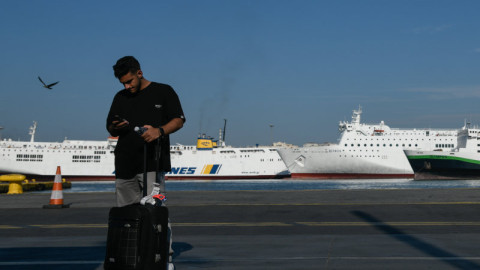 άνδρας με βαλίτσα σε λιμάνι Πειραιά με πλοία