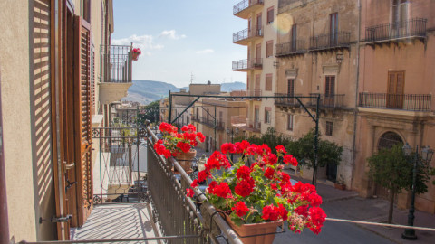 κόκκινα λουλούδια σε μπαλκόνι στη Σικελία