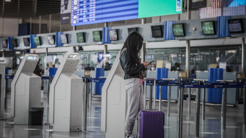 κοπέλα με βαλίτσα σε αεροδρόμιο