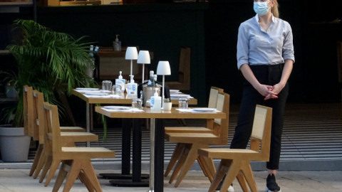 σερβιτόρα κοντά σε τραπέζι με καρέκλες 