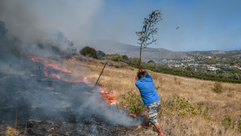 άνδρας σβήνει φωτιά στην Κερατέα