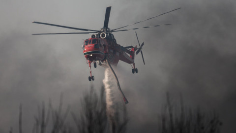 ελικόπτερο ρίχνει νερό σε φωτιά στη Βαρυμπόμπη