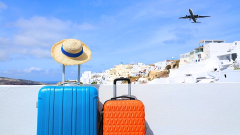 Αποσκευές με φόντο σπίτια στην Οία στο νησί της Σαντορίνης