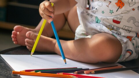 Μικρό παιδί που μαθαίνει να ζωγραφίζει με ξυλομπογιές