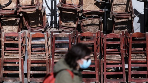 Μια γυναίκα περπατά μπροστά από κλειστό κατάστημα εστίασης