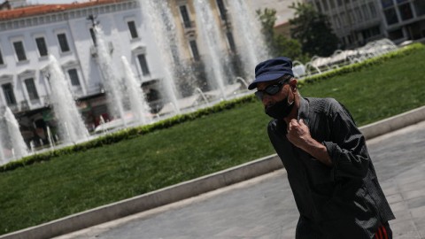 άνδρας με μαύρα ρούχα σε πλατεία Ομονοίας το καλοκαίρι