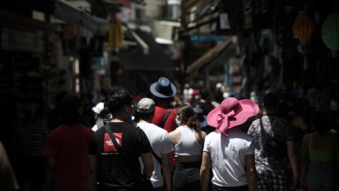 κόσμος με καπέλα περπατάει στο Μοναστηράκι στην Ελλάδα το καλοκαίρι