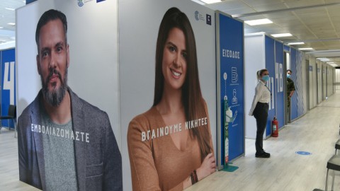 κόσμος έξω από αίθουσες σε εμβολιαστικό κέντρο