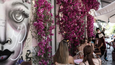 κόσμος κάθεται σε μαγαζί εστίασης